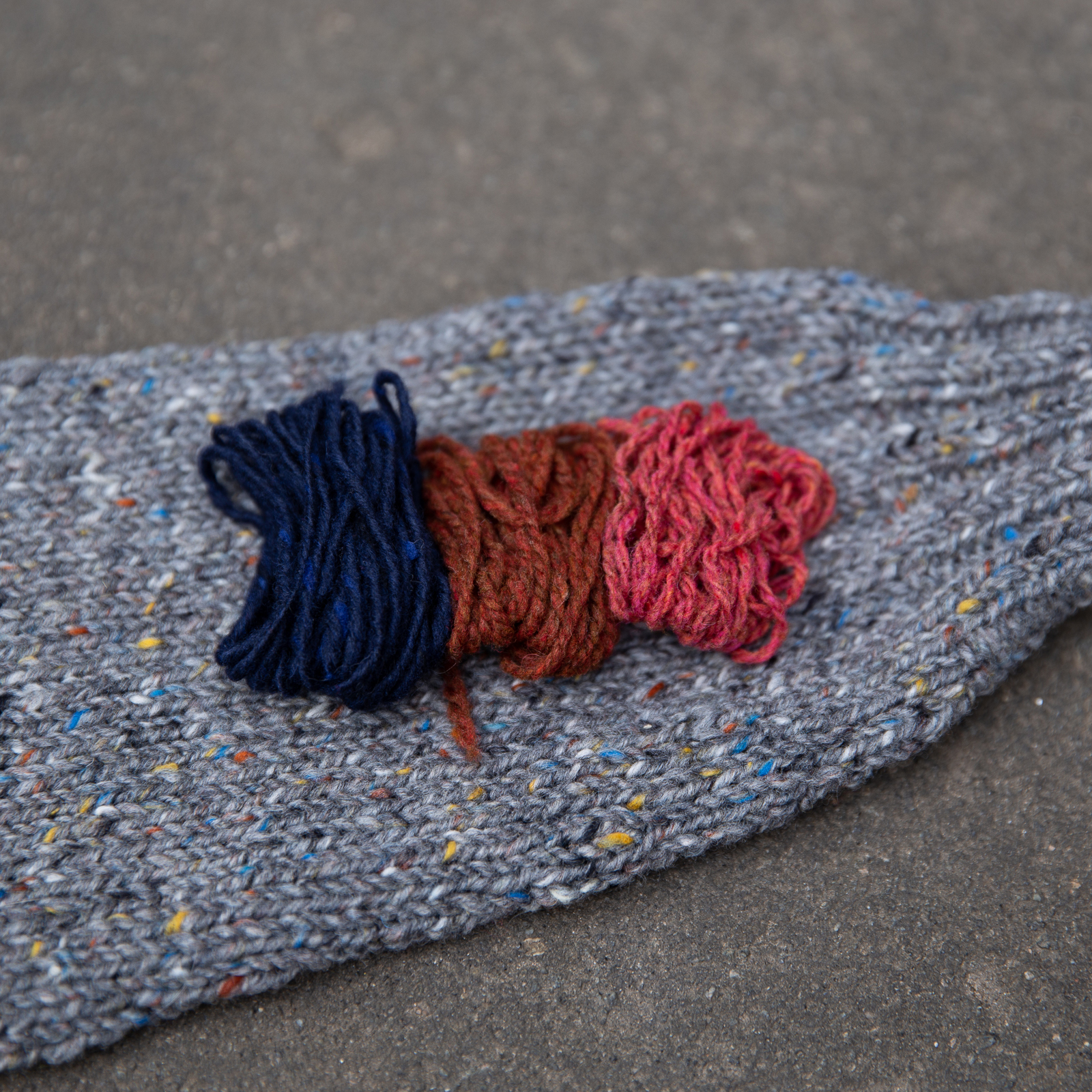 yarn palette of navy blue, rust, salmon