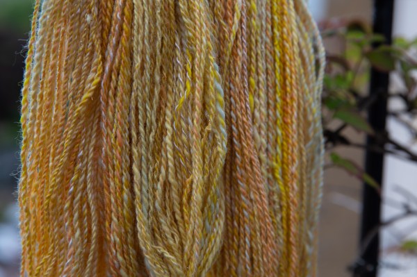yellow, pink, and white two-ply yarn