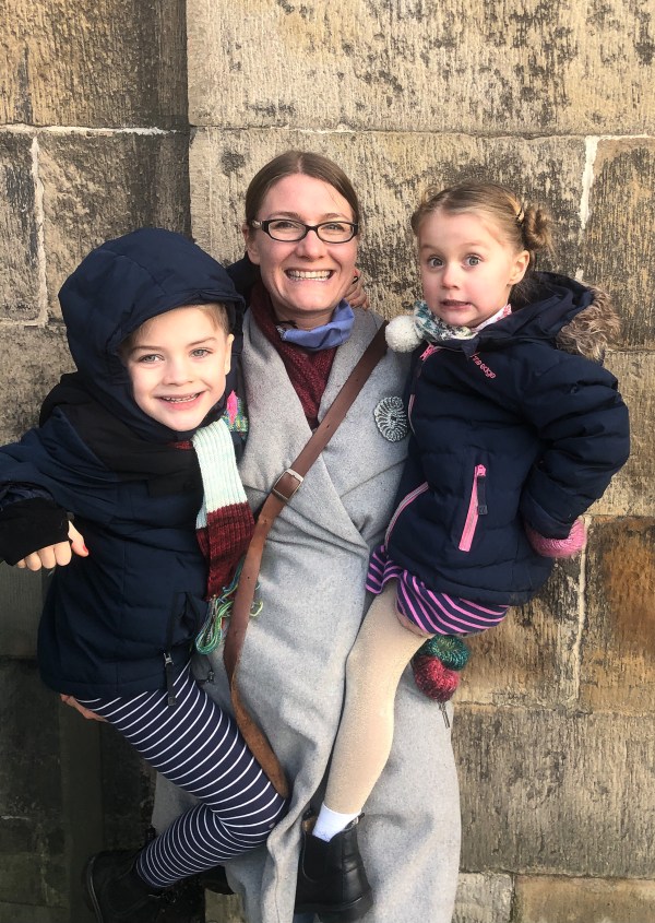 woman holding two children